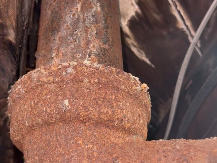 Before: a heavily rusted cast-iron drain stack